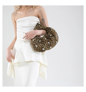Detail of leopard print hobo bag featuring silver metal studs and pleated texture