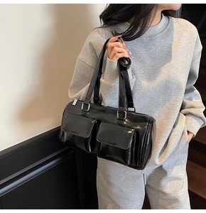 Chic black patent leather pillow bag styled with casual grey sportswear on model