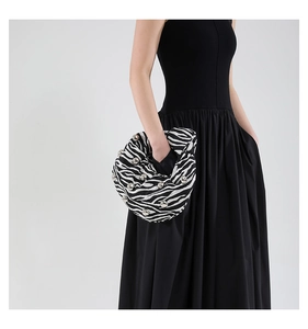 Close-up of zebra print cloud bag featuring silver studs and knot design on handle