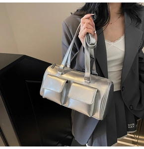 Detail of silver metallic cylinder bag with dual front pockets and glossy liquid finish