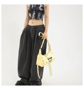 Fashionable bright yellow rivet bag styled with oversized pants and platform shoes