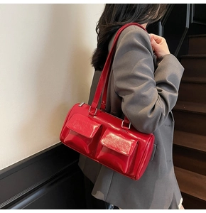Detail of red patent leather shoulder bag with glossy finish and silver buckle hardware