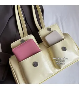Close-up of front flap pockets on a cream shoulder bag showing phone storage detail