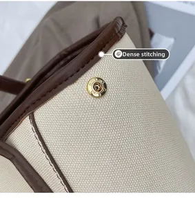 Détail du sac cabas en toile avec bordures en cuir marron et fermoir aimanté doré