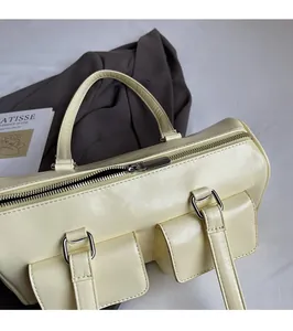 Close-up of light yellow vintage leather underarm bag with silver hardware and pockets