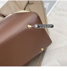 Détail du fond de sac cabas avec rivets de protection dorés et coutures en toile