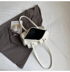 Interior view of white leather shoulder bag with black lining and top zipper detail