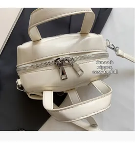 Detail of high-quality smooth silver zipper on a cream-white PU leather crossbody bag