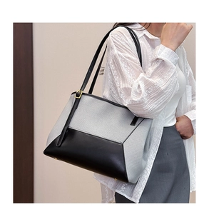 Détail du sac cabas gris et noir avec ferrures dorées et texture en toile et cuir