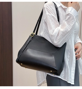 Détail du sac cabas en cuir noir avec boucle dorée sur la bandoulière réglable