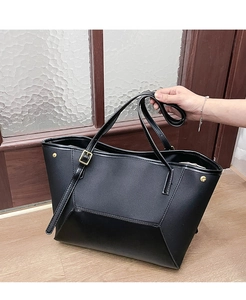 Détail du grand sac cabas en cuir noir avec rivets dorés et bandoulière réglable