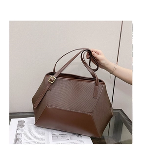 Vue macro du tissu marron texturé et du patchwork en cuir sur un grand sac cabas