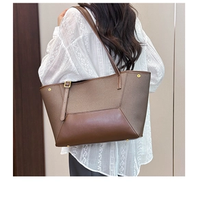Détail du sac cabas en cuir marron avec texture vintage et rivets dorés élégants