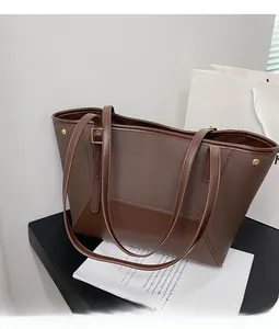 Détail du grand sac cabas marron foncé montrant les textures en tissu et cuir mélangés