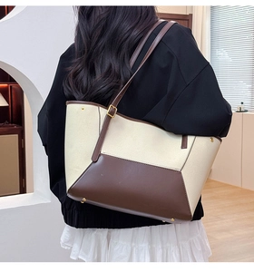 Détail de la bandoulière en cuir réglable et boucle dorée sur un sac cabas en toile