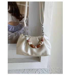 Detail of cream cloud bag with agate textured bead handle and soft pleated leather