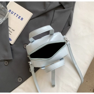 Top view of a light blue PU leather handbag with open zipper and interior lining details