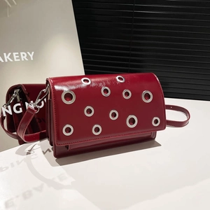 Minimalist burgundy patent leather crossbody bag with silver rivet eyelet accents