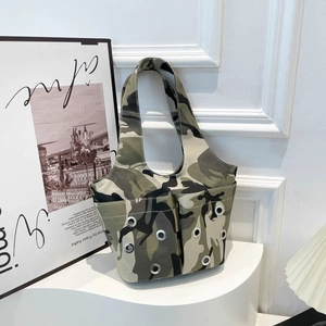 Camouflage canvas shoulder bag with silver eyelets and dual pockets on display