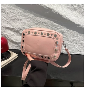 Piccola borsa a tracolla rosa lucida con decorazioni di borchie argentate ai bordi