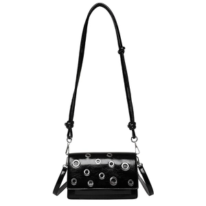 Glossy black patent leather crossbody bag with silver punk eyelet studs and slim straps