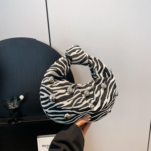 Zebra print hobo bag with silver bead accents and knotted handle in a stylish minimalist setting