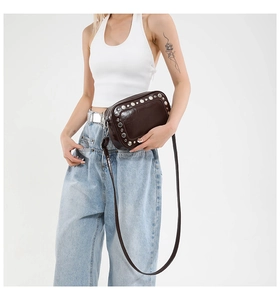 Dettaglio borsa a tracolla marrone scuro con borchie e outfit minimalista