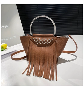 Dettaglio borsa a secchiello in pelle marrone con frange e manico ad anello metallico