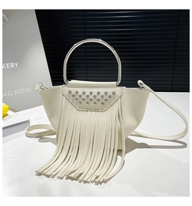 Dettaglio borsa bianca in pelle litchi con manico ad anello argento, borchie e nappe