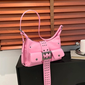 Pink punk-style shoulder bag with silver studs and buckles on a minimalist background