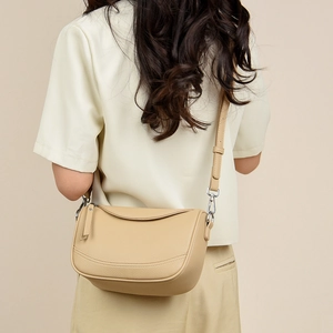 Detail of beige lychee pattern leather crossbody bag with adjustable shoulder strap
