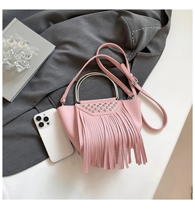 Dettaglio della borsa rosa texture litchi con manici in metallo e frange eleganti