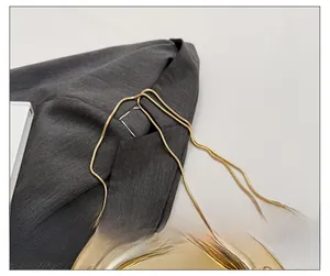 Detail shot of a glossy gold acrylic evening bag with a sleek snake chain shoulder strap