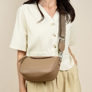 Detail of khaki pebbled leather crossbody bag with geometric woven shoulder strap