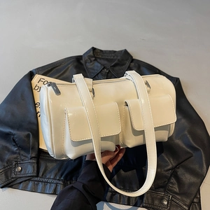 Creamy white cylinder shoulder bag with side flap pockets and glossy leather finish