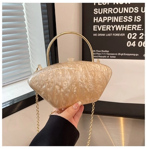 Dettaglio della pochette in acrilico champagne con trama marmorizzata e manico d'oro