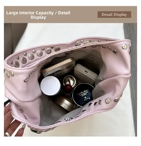 Pink studded bucket bag interior showing spacious storage for phones and makeup