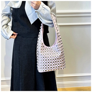 Detail of pink hobo bag featuring decorative silver studs and a wide shoulder strap