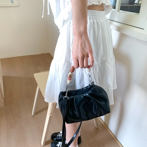 Fashionable black pleated cloud handbag with chunky amber bead handle and crossbody strap