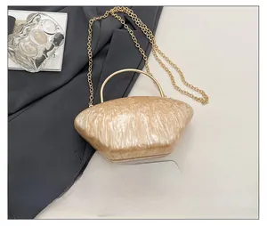 Borsa da sera in acrilico perlato champagne mostrata accanto a uno smartphone