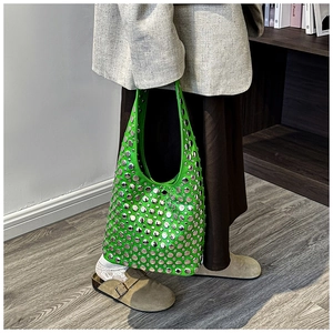 Detail of vibrant green hobo bag with silver metallic rivets and high-gloss PU finish