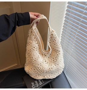 Detailaufnahme der cremeweißen Häkeltasche mit floralem Lochmuster und breitem Schultergurt