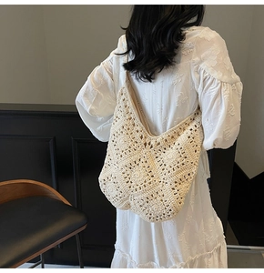 Detailansicht der beigefarbenen Häkeltasche mit Boho-Blumenmuster an einem Modell