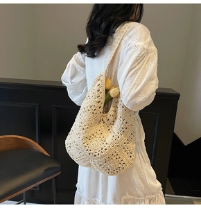 Detail der handgewebten floralen Textur an der beigen Häkel-Schultertasche