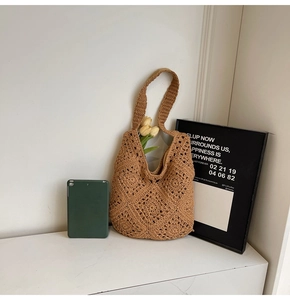 Detail eines handgewebten Lochmusters an einer braunen Häkeltasche mit dekorativer Tulpe