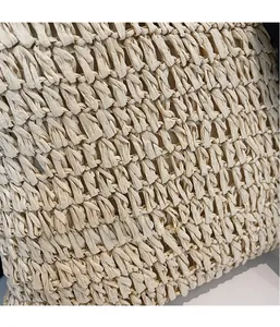 Macro shot of 3D textured weaving on a beige straw beach bag with intricate fiber details