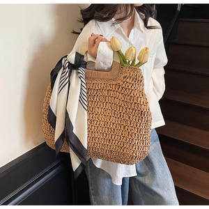 Close-up of woven straw tote bag featuring a striped scarf and yellow tulip accents
