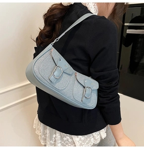 Detail der hellblauen Baguette-Tasche mit Denim-Struktur und silbernen Schnallen