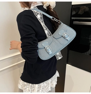 Detail der hellblauen Baguette-Tasche mit Fronttaschen und silbernen Metallschnallen