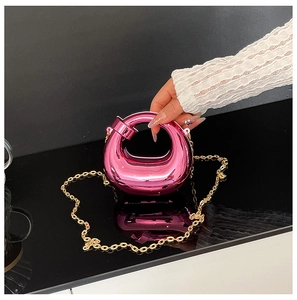 Dettaglio mini borsa da sera in acrilico rosso rosa con finitura a specchio e catena